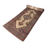 AN OLD PERSIAN HAMADAN LONG RUNNER with an interlocking hooked diamond pattern on a camel ground,