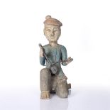 AN OLD FAR EASTERN CARVED AND POLYCHROME DECORATED FIGURE of a seated musician playing a stringed