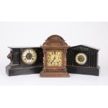 An American black mantle clock with lion mask ornament to either end; an old slate mantle clock with