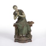 An antique Continental painted pottery figure depicting a seated lady, signed L Madrassi, 33cm