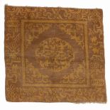 Gold ground rug Chinese with traditional motifs, 80cm x 76cm Condition: wear and losses to the