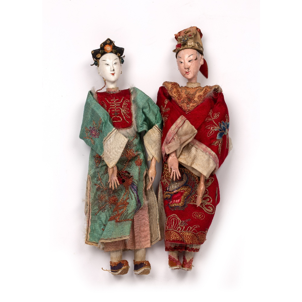 Two dolls Chinese with painted white faces, dressed in elaborate embroidered clothes, 28cm high (