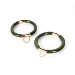 Two spinach jadeite bangles Chinese with yellow metal mounts, 7.5cm across (2) Condition: general