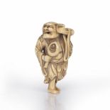 Ivory netsuke of a standing Sennin Japanese, 18th Century Kyoto School holding a lotus bud within