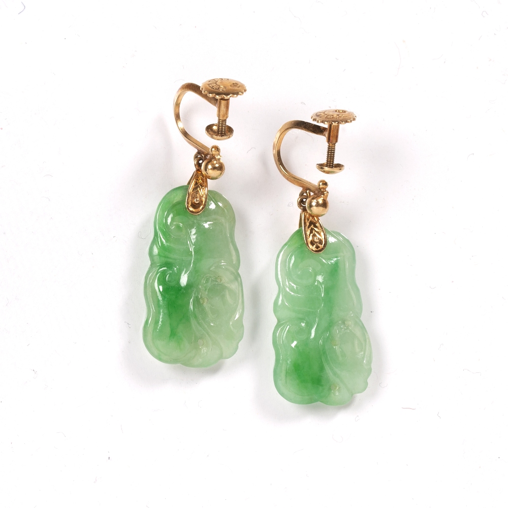Pair of jade earrings Chinese carved as an animals, suspended by a gold metal backing stamped 18k,