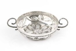 An early 20th century Britannia Standard silver taste vin, embossed with a flowerhead and foliage,