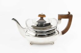 A silver teapot, with gadrooned border, composite handle and knop, on ball feet, by S
