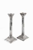 A pair of silver candlesticks, of Corinthian column form, on beaded stepped square bases, by