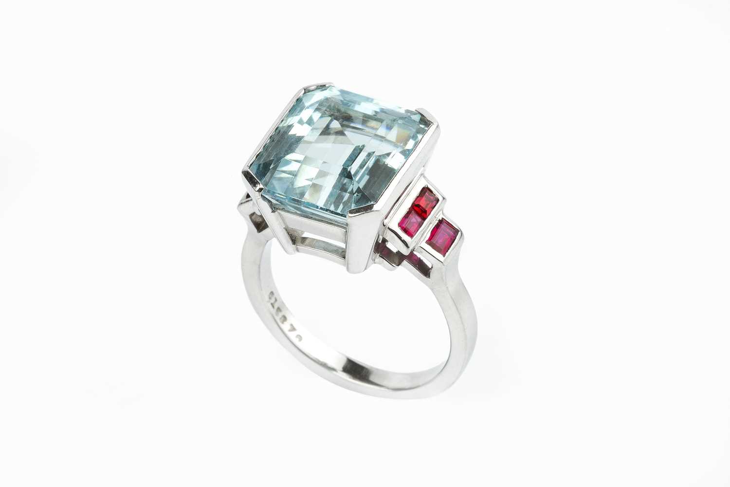 An aquamarine and ruby dress ring, the octagonal step-cut aquamarine in raised part-collet