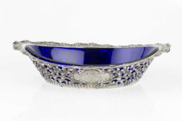 A late Victorian silver oval dish, repoussé and pierce decorated with flowers and scrolling foliage,