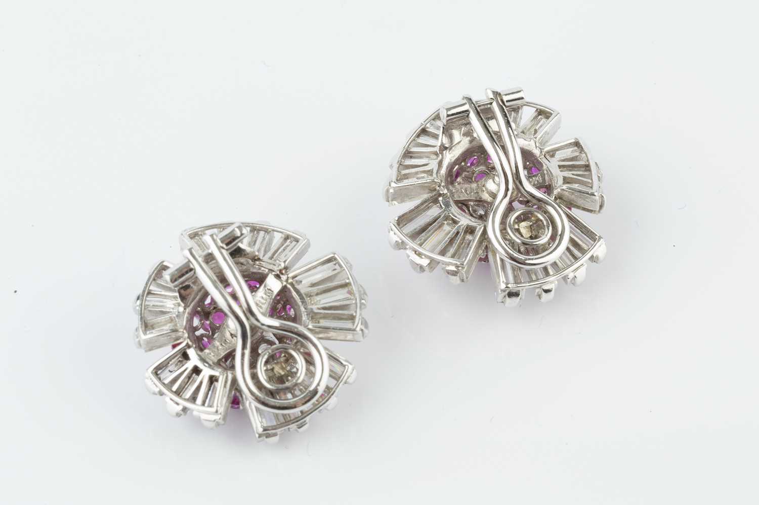 A pair of ruby and diamond cluster ear clips, each designed as a stylized flowerhead, centred with a - Image 2 of 3