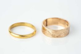 A 22ct gold wedding band, and a rose precious metal wedding band, with foliate scroll engraved