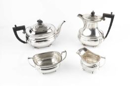 A silver four piece tea service, with gadrooned borders, the teapot and hot water pots with ebonised