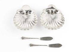 A pair of late Victorian silver butter shells, on bun feet, and with matching butter knives, by