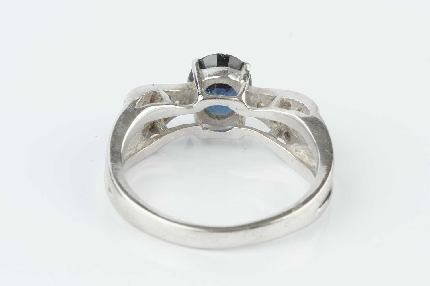 A sapphire and diamond dress ring, the oval mixed-cut sapphire claw set between wishbone-shaped - Image 2 of 2