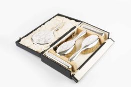 A silver dressing table set, engraved with ribbon tied swags, comprising a hand mirror, two