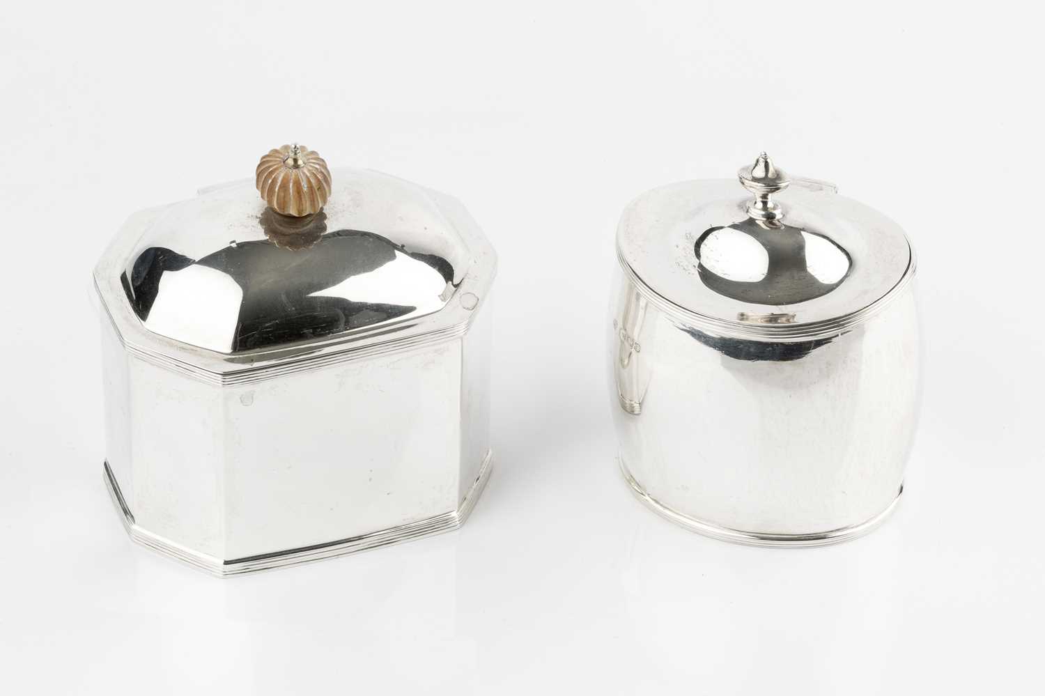 A silver tea caddy, of chamfered rectangular form, with reeded borders and lobed composition finial,