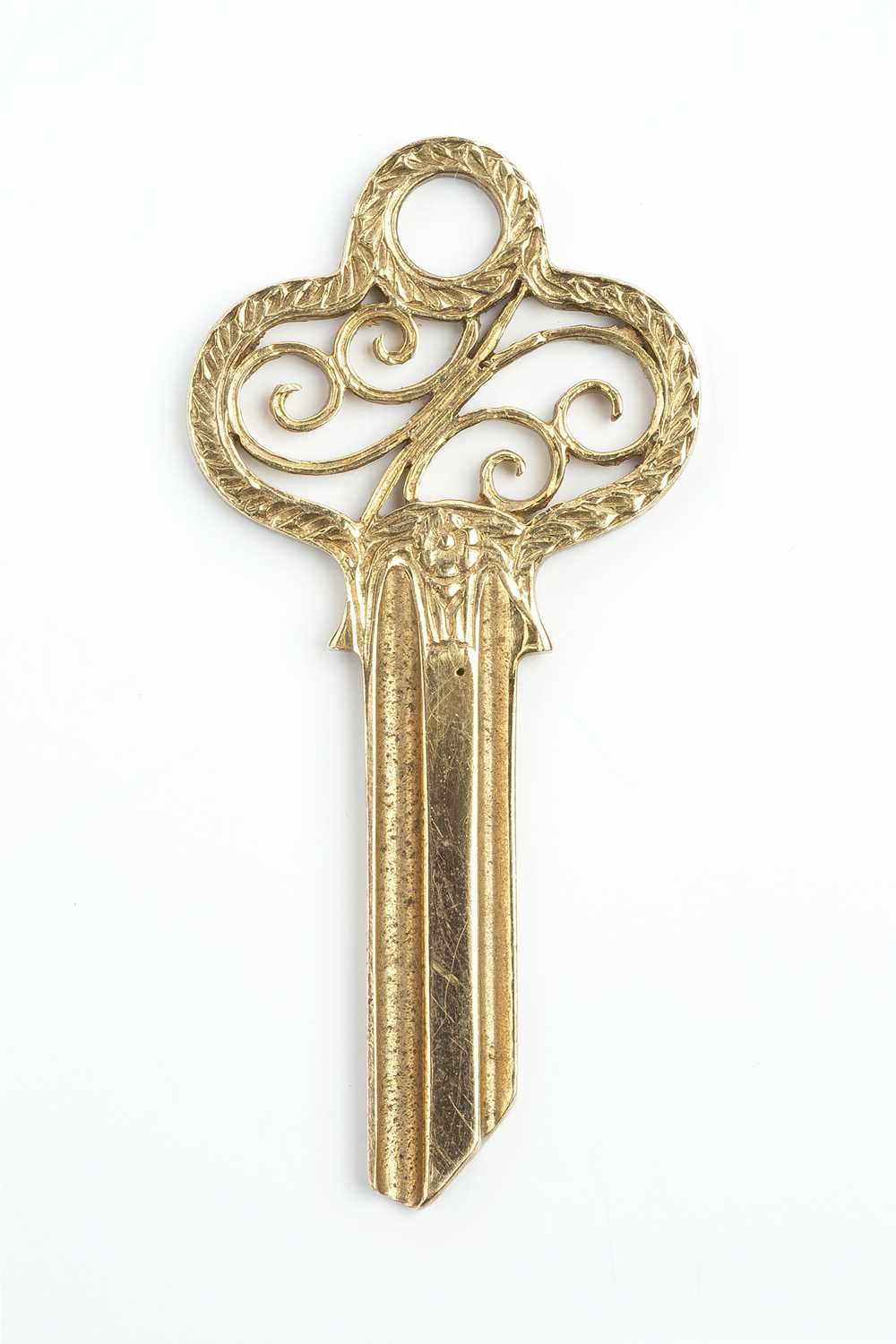 A 9ct gold key, the openwork scrolled surmount with foliate border, hallmarked for London 1965,