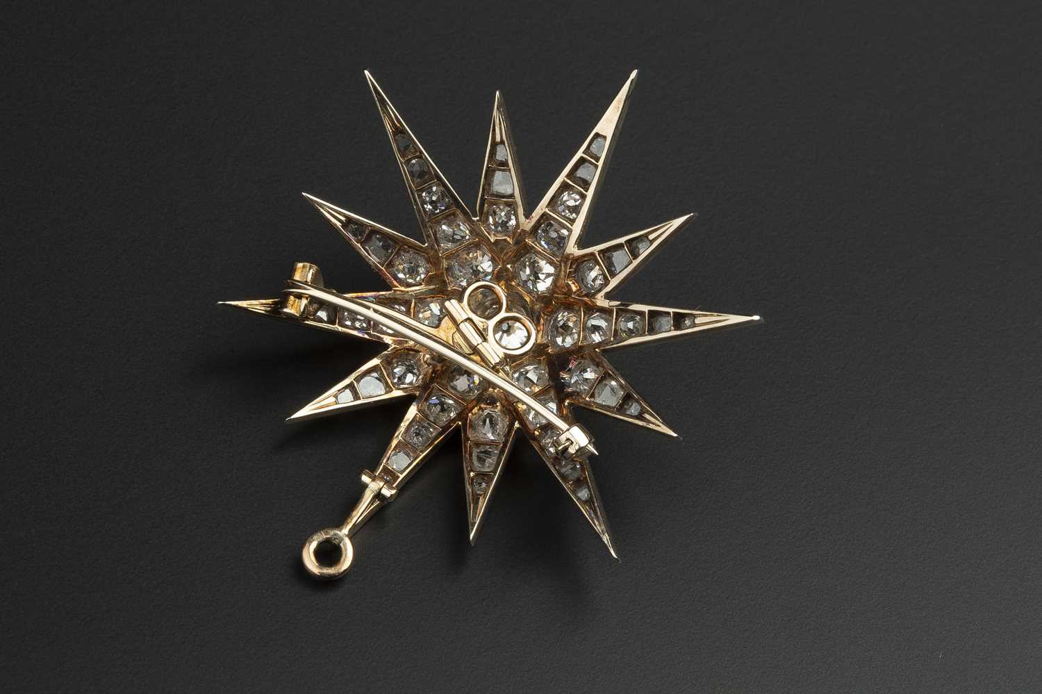 A late 19th/early 20th century diamond star brooch, the principal old-cut diamond bordered by rays - Image 3 of 3