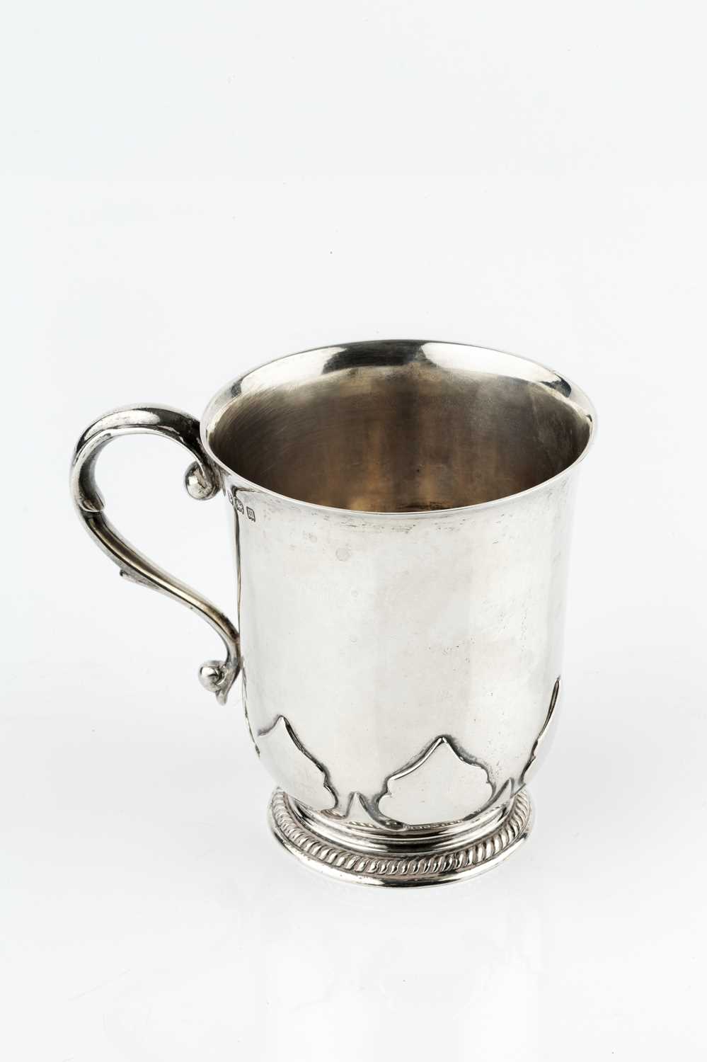 A silver christening mug, with slightly flared rim, and scroll handle, the gadrooned base with
