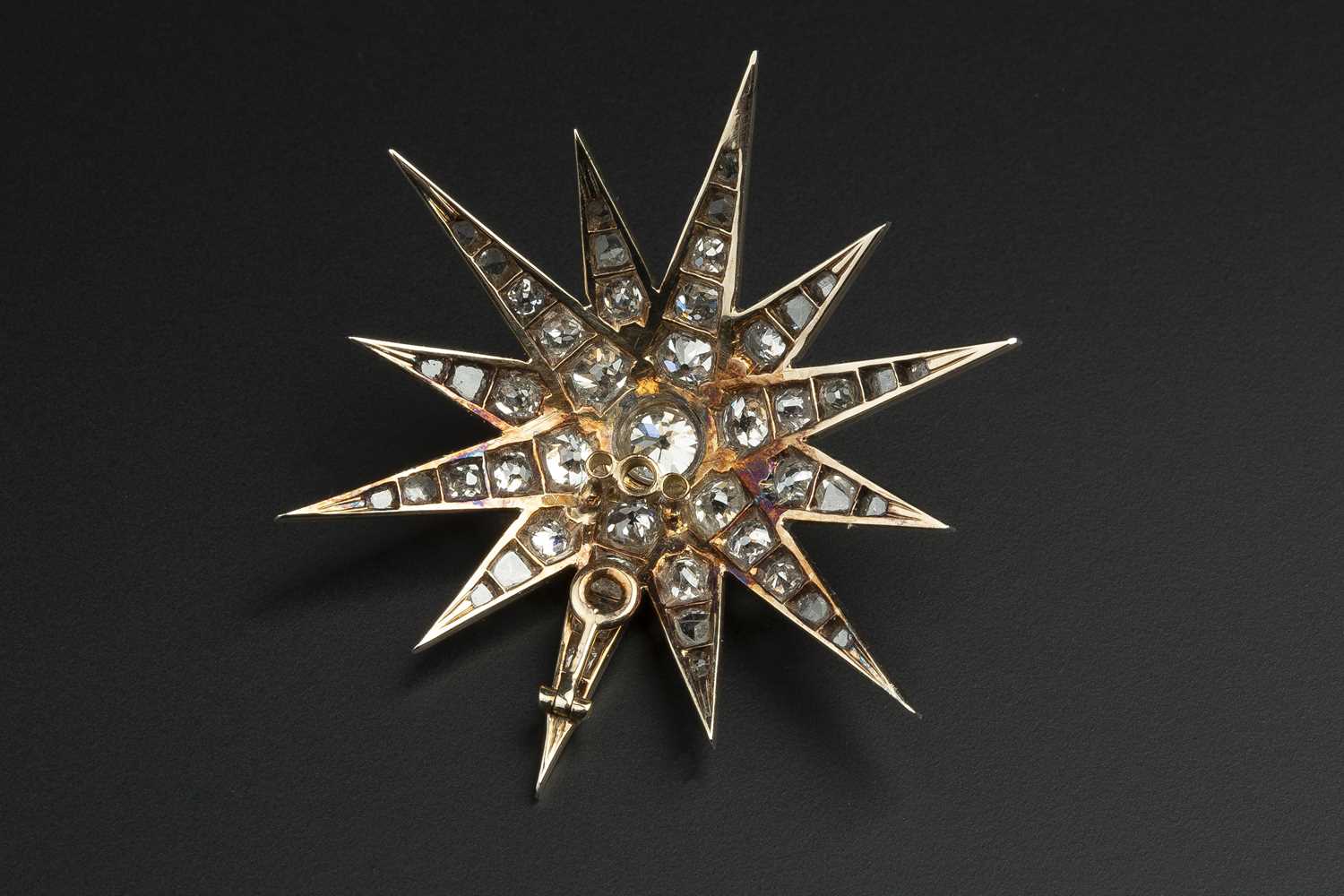 A late 19th/early 20th century diamond star brooch, the principal old-cut diamond bordered by rays - Image 2 of 3