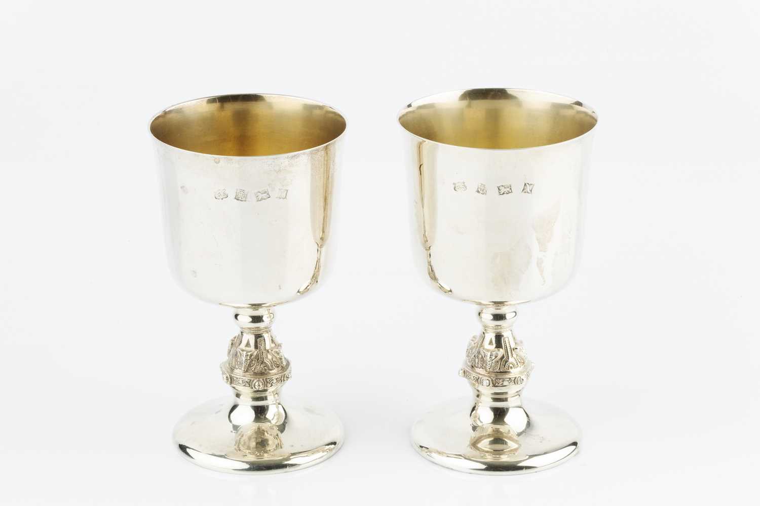 A pair of silver goblets, with plain, slightly flared bowls, and ornate knopped stems, by