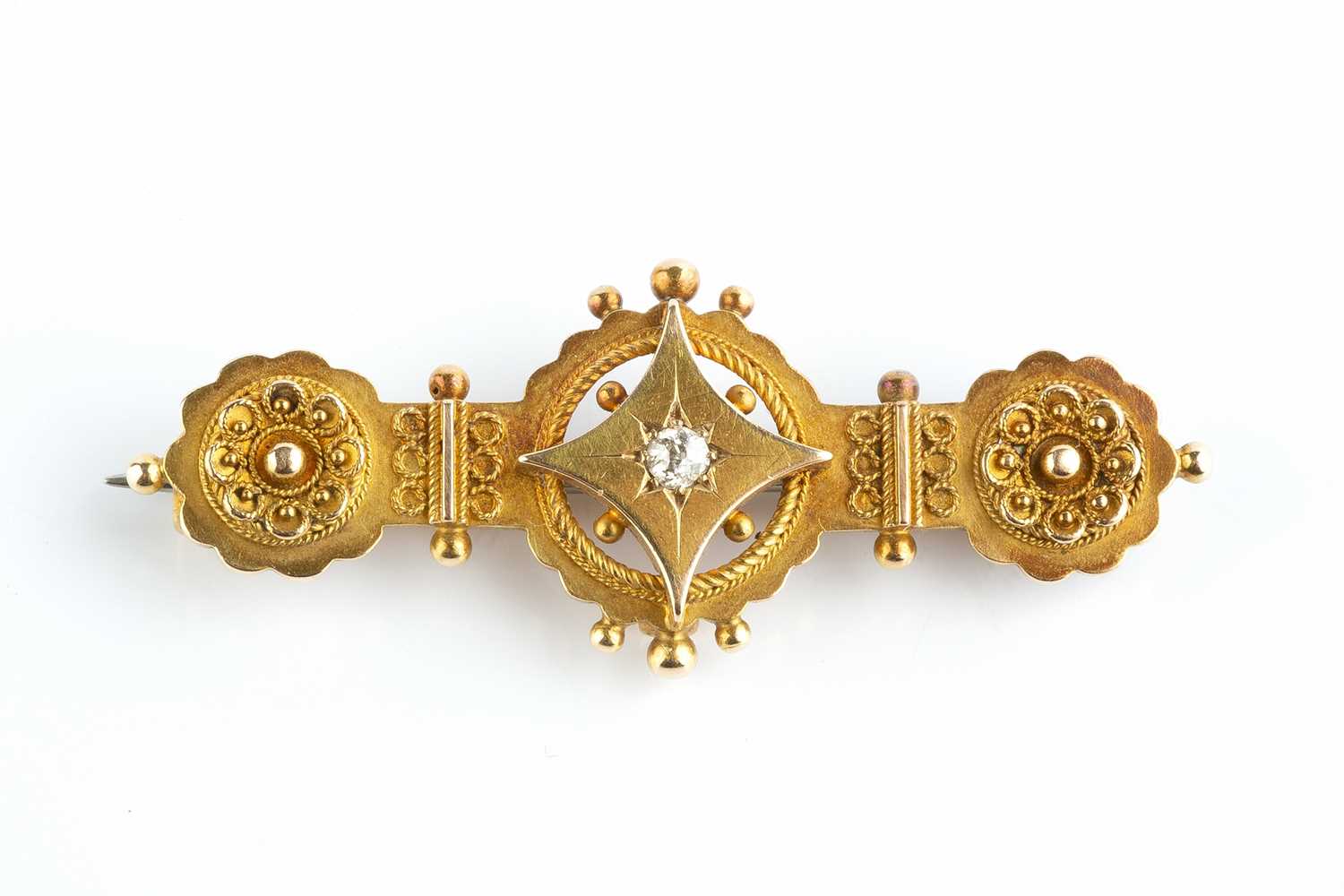 A late Victorian diamond set panel brooch, centred with an old-cut diamond set lozenge, with