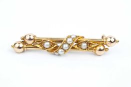 A late Victorian half pearl set brooch, designed as a double bar with bead terminals, centred with a