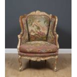 A 19th century continental beechwood framed wing back armchair with tapestry upholstery and cabriole