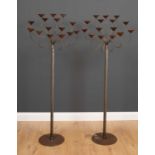 A pair of floor standing wrought steel fifteen light candelabras with cable twist stems and circular