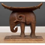 An African carved wooden African tribal stool with concave seat and elephant support53cm x 32cm x