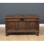 An 18th century and later oak coffer with triple panelled lid and front, standing on stile feet,