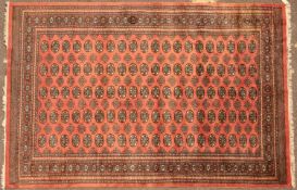 A pink ground Bokhara 'Elephant's Foot' patterned rug 283cm x 186cmCondition report: Of modern
