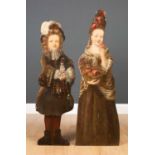 A pair of antique dummy boards depicting a boy with a spaniel and a girl with a basket of flowers,