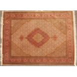An Oriental pink ground rug with central diamond motif and within a multiple banded border, 200cm