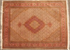 An Oriental pink ground rug with central diamond motif and within a multiple banded border, 200cm