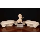 A limed carved wooden cherub mounted on a perspex stand together with two limed carved pine ionic