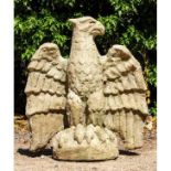 A cast reconstituted stone sculpture of an eagle with wings spread and perched on a domed base, 76cm