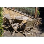 A circular teak garden table together with four folding chairs, the table 91cm diameterCondition