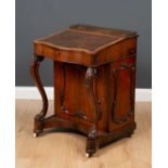 An early Victorian rosewood Davenport desk, the leather inset fall with serpentine front, lifting to