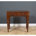 A continental walnut side table with three shallow drawers and standing on square tapering legs,