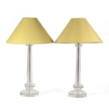 A pair of faceted cut glass table lamps of octagonal form with stepped bases and light green shades,