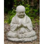 A cast reconstituted stone ornament in the form of a Budda figure sitting cross-legged, 49cm wide