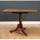 A 19th century mahogany tilt top tripod table with turned column support and reeded splaying legs on