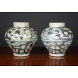 A pair of antique South East Asian jars decorated with scrolls and flowers, 20.5cm diameter x 22cm