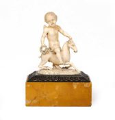 An antique possibly Italian carved ivory figure of a putti riding on the back of a goat, mounted