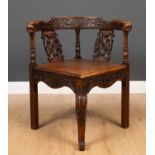 A 19th century carved oak corner chair with serpent handles, 69cm wide x 70cm deep x 75cm high at