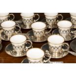 A set of twelve white metal and porcelain espresso coffee cups with gilt line ornament to the