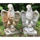 Two similar of cast reconstituted stone finials in the form of eagles grasping fish, each 50cm