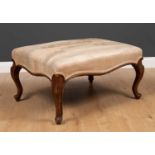 A continental style walnut rectangular stool with overstuffed upholstered seat and carved cabriole